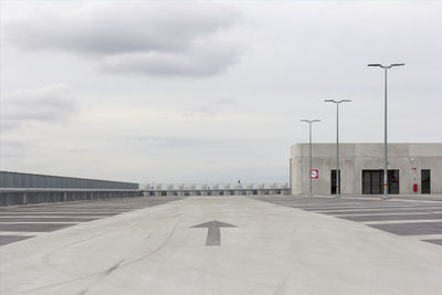 Street leading towards building against sky