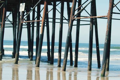 Wooden pier on sea against sky