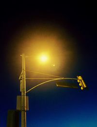 Low angle view of illuminated street light against sky