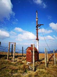 Traditional windmill on field against sky