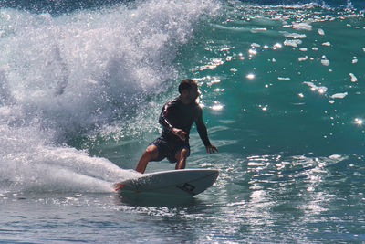 Rear view of man surfing in sea