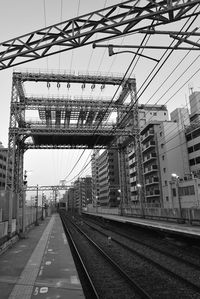 Railroad tracks in city against sky