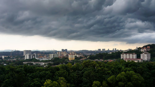 Buildings in city against cloudy sky
