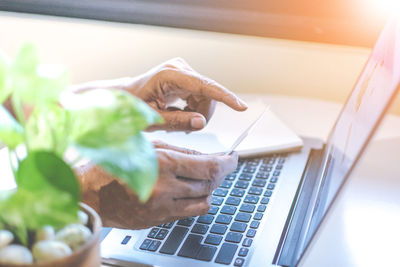 Man shopping online on laptop from credit card at table