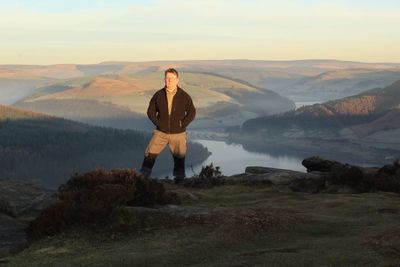 Portrait of man standing on mountain against sky