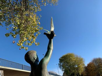 Low angle view of statue against clear blue sky