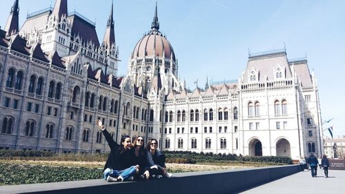 Tourists in front of historic building against sky