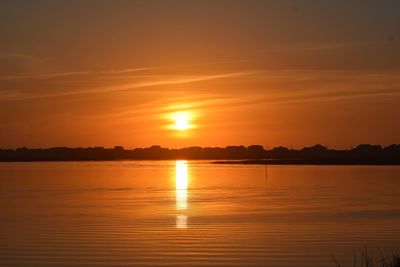 Scenic view of lake against romantic sky at sunset