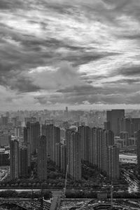 View of cityscape against cloudy sky