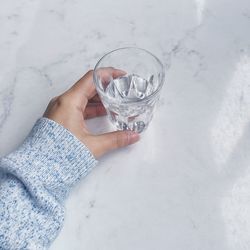 Cropped image of hand holding drinking glass