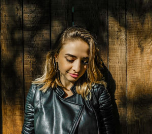 Young woman against wooden wall