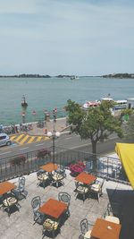 High angle view of city by sea against sky