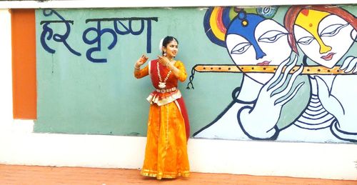 Young woman standing on wall