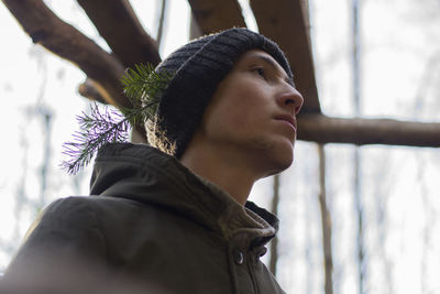 Low angle view of man with twig in knit hat