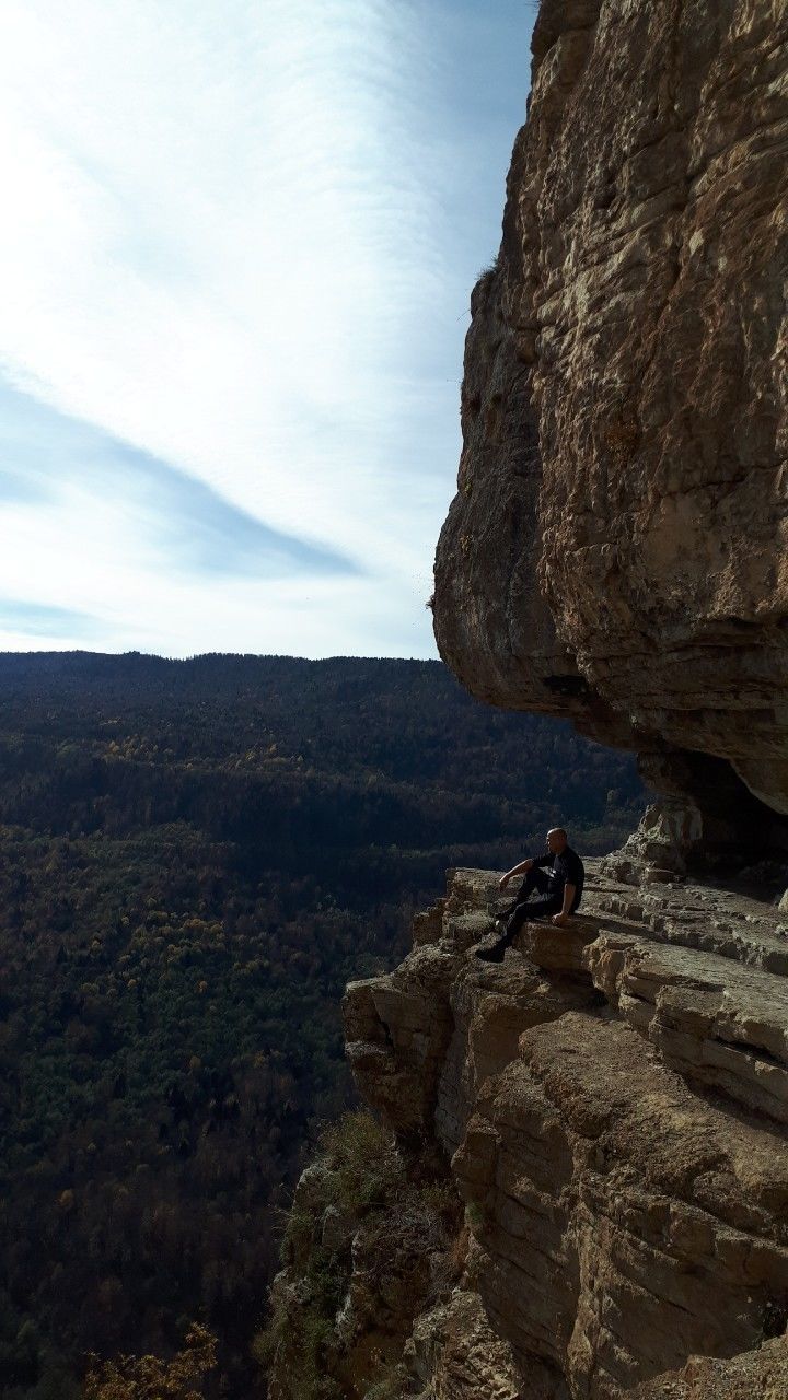 mountain, rock, adventure, rock - object, solid, activity, leisure activity, sky, one person, rock formation, climbing, real people, nature, sport, full length, beauty in nature, lifestyles, day, rock climbing, outdoors, mountain range, skill