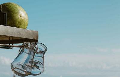 Close-up of apple on glass against sky