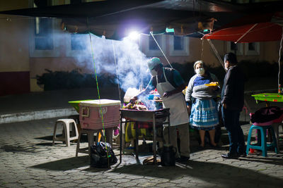 Rear view of people at market stall on street