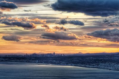 Scenic view of dramatic sky over city during sunset