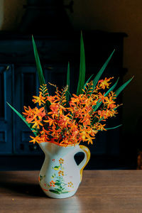 Close-up of orange flower pot on table