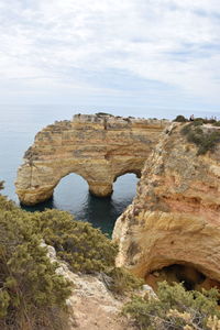 Rock formations by sea against sky