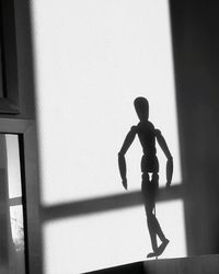 Silhouette boy walking against wall