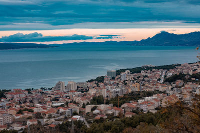 High angle view of townscape by sea against sky