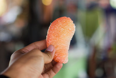 Close-up of hand holding orange
