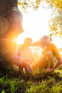 Rear view of man sitting on grassy field