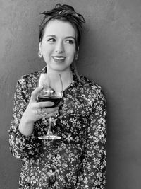 Portrait of smiling woman standing against wall