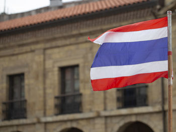 Low angle view of flag against building in city