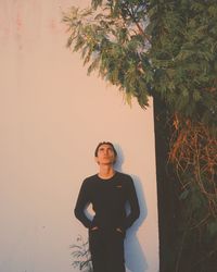 Portrait of young woman standing against plants