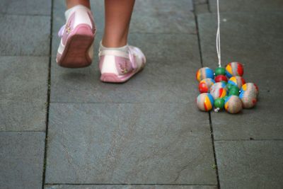 Low section of woman wearing multi colored shoes