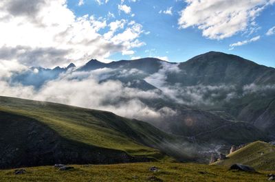 Scenic view of mountains against cloudy sky