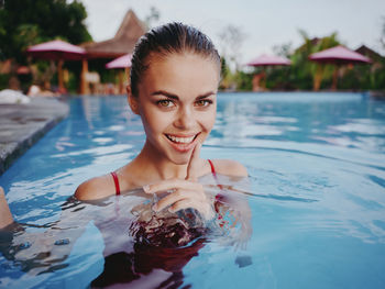 Portrait of smiling young woman in swimming pool