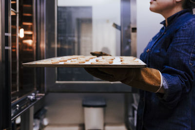 Midsection of woman making food in commercial kitchen