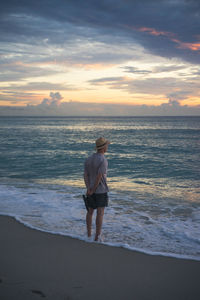 Full length of man standing on beach during sunset