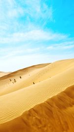 Sand dunes in desert against sky