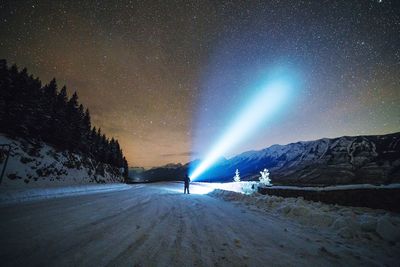 Snow covered landscape against sky at night