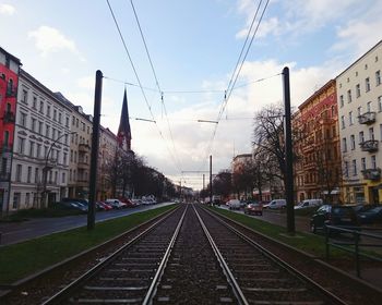 Railroad tracks against cloudy sky