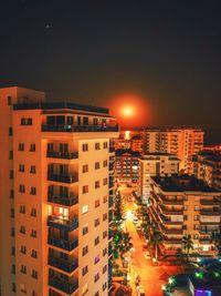 High angle view of illuminated buildings against sky at night