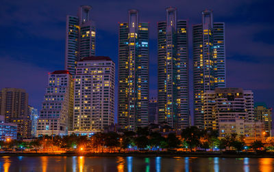 Illuminated buildings against sky at night