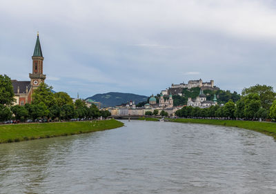 River amidst buildings in city against sky