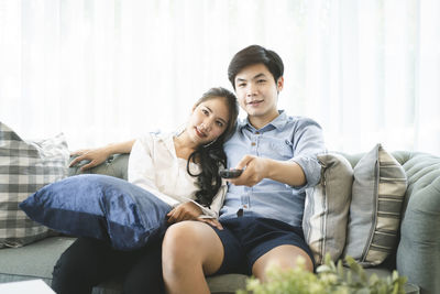 Happy young couple sitting on sofa