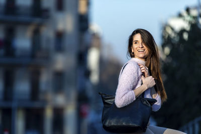 Smiling woman sitting in city