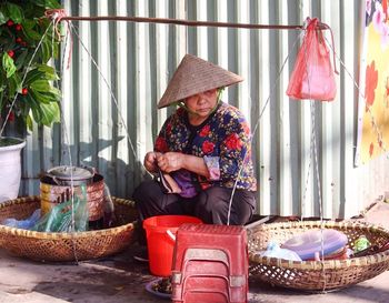 Rear view of woman sitting on wall