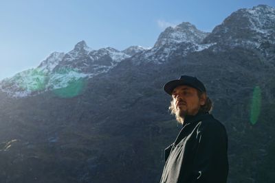 Portrait of man standing on mountain against sky