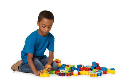 Boy playing with toy against white background