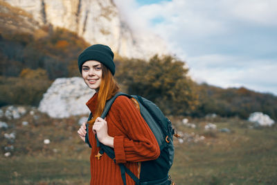 Young woman wearing hat standing in park during winter