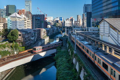 Bridge over canal amidst buildings in city against sky