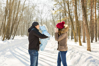 Full length of people on snow covered tree